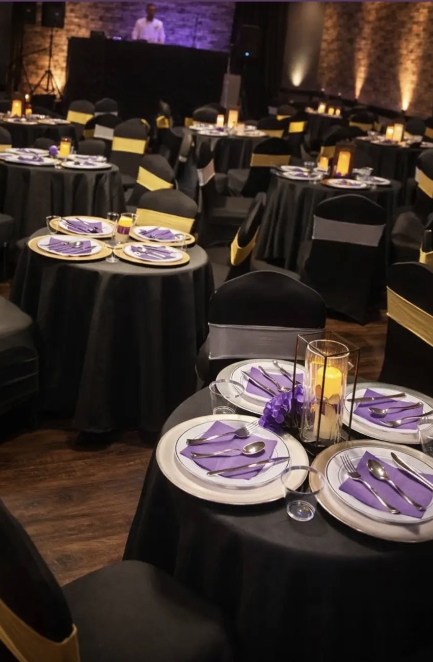 Long candlelit dinner table with red roses and gold candelabras